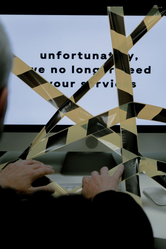 Computer screen with caution tape depicting office closure or job termination.